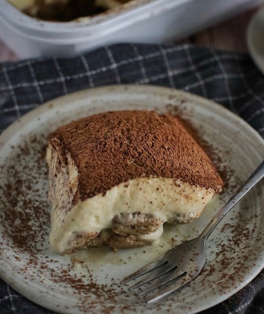 Slice of tiramisu cake plated with fork